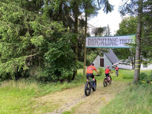 three people riding bikes down a dirt road at Berghotel Talblick in Holzhau