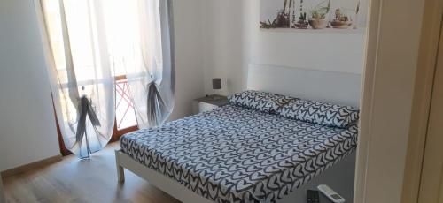 sypialnia z łóżkiem w pokoju z oknem w obiekcie Nonna Pella Appartamenti - Rosmarino w mieście Pietra Ligure