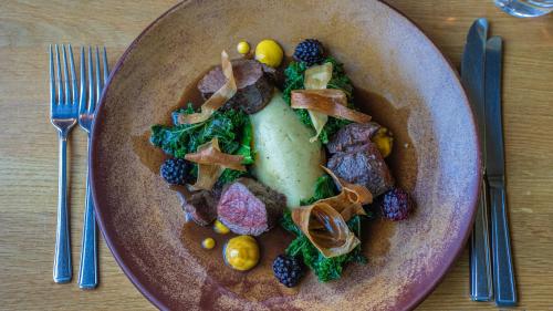 a plate of food with meat and fruit on a table at The Peat Spade Inn in Stockbridge