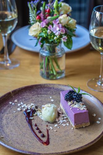 a plate with a dessert on a table with flowers at The Peat Spade Inn in Stockbridge