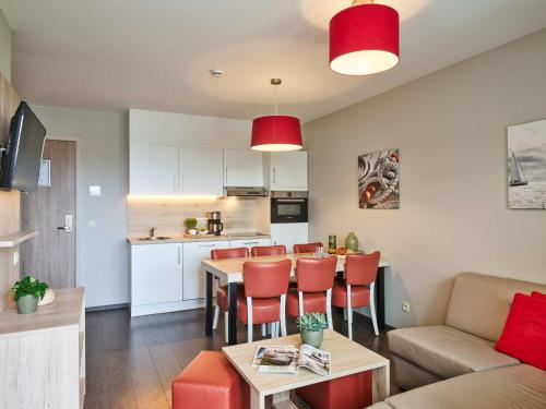 a living room and kitchen with a table and chairs at Holiday Suites Zeebrugge in Zeebrugge