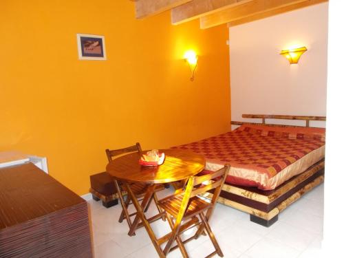 Cette chambre comprend un lit, une table, une table et des chaises. dans l'établissement Aux Amandiers, à Fréjus