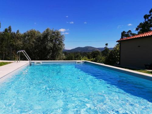 a swimming pool with blue water in a house at Casa dos Matos in Ponte de Lima