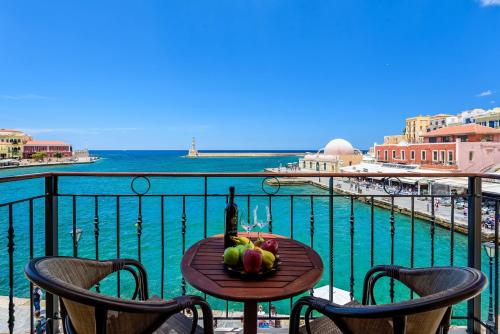 a table with a bottle of wine and fruit on a balcony at Belmondo Hotel in Chania Town