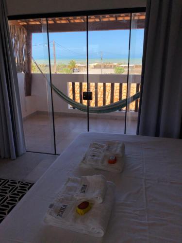 a room with two towels on a bed with a view of the beach at Gostoso White in São Miguel do Gostoso