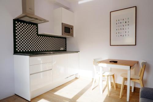 a kitchen with white cabinets and a table at Hotel Andalucia in Lanjarón