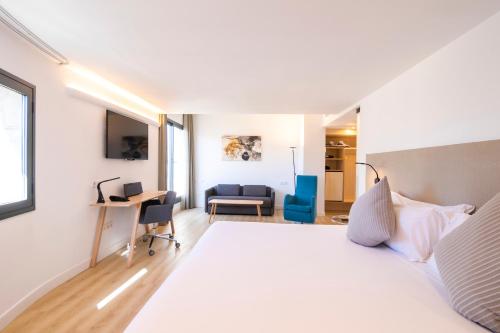 a bedroom with a large white bed and a desk at INNSiDE by Meliá Palma Center in Palma de Mallorca