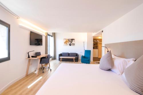 a living room with a bed, chair and a tv at Innside by Melia Palma Center in Palma de Mallorca