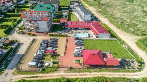 uma vista aérea de uma casa com carros estacionados num parque de estacionamento em Pokoje i Domki "Zaciszny" - Mielno em Mielno