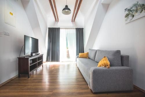 a living room with a couch and a tv at Pataky Apartmanok in Veszprém