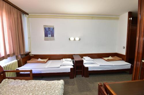 a hotel room with two beds and a table at Apartments JAT Kopaonik in Kopaonik
