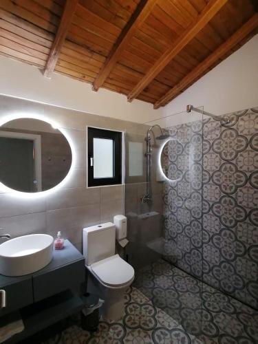 a bathroom with a sink and a toilet and a mirror at Casa dos Matos in Ponte de Lima