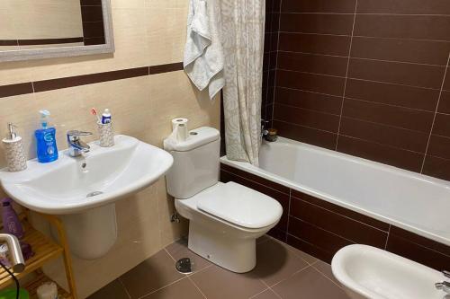 a bathroom with a toilet and a sink and a tub at Apartamento en Boiro in Boiro