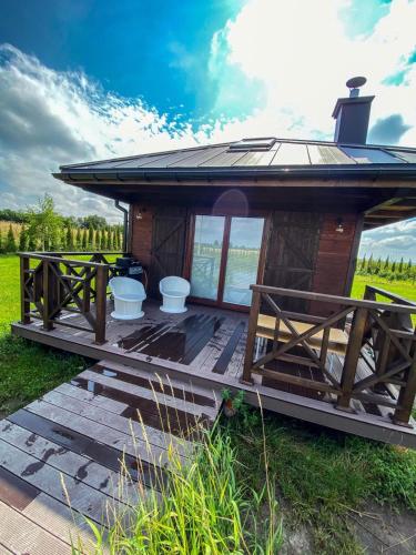 a small cabin with a roof on a deck at Luksusowe całoroczne domki z widokiem Janowiec in Janowiec