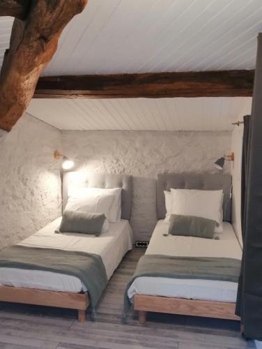twee bedden naast elkaar in een kamer bij Le cottage de l'étang in Le Tablier