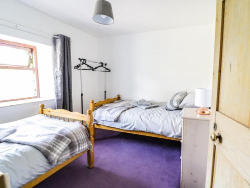 a bedroom with two beds and a window at Arosfa in Bala