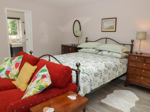 1 dormitorio con cama, sofá y espejo en Robins Rest, en Yelverton