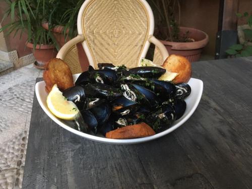 a bowl of mussels and lemon slices on a table at Hotel Elimo in Erice