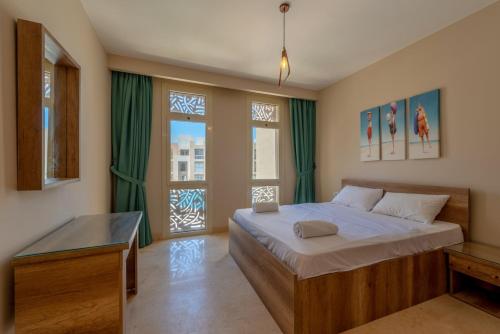 um quarto com uma cama grande e uma janela em Mangroovy 3BR Apartment Private Beach & Pool View em Hurghada