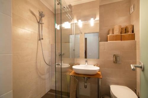 ein Bad mit einem Waschbecken und einer Glasdusche in der Unterkunft Apartament, Ultracentral, Piata Victoriei in Bukarest