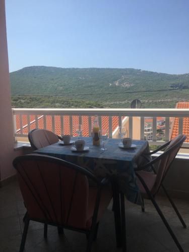 a table and chairs on a balcony with a view at Apartments MAMPAS in Neum