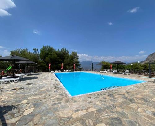 una piscina en un complejo con montañas en el fondo en Bungalow - Camping Apollon, en Delfos