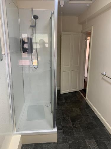 um chuveiro com uma porta de vidro na casa de banho em Ivy Green inn em Huddersfield
