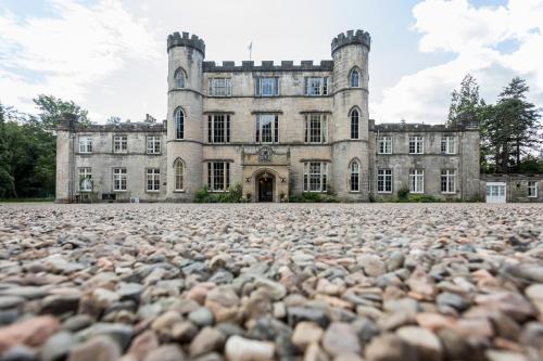 an old castle with a large pile of rocks in front of it at Melville Castle Hotel in Edinburgh