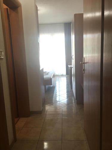 einen Flur mit Tür und ein Zimmer mit Fenster in der Unterkunft Apartments MAMPAS in Neum