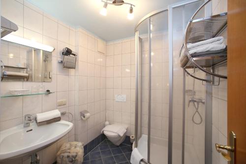 a bathroom with a shower and a sink and a toilet at Hotel Eder Michaela in Saalbach Hinterglemm