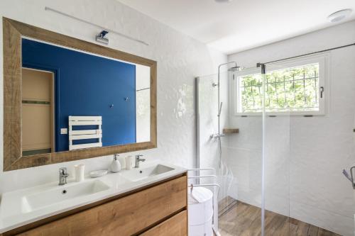 a bathroom with a sink and a shower and a mirror at La Déferlante - Maison familiale à Cancale in Cancale