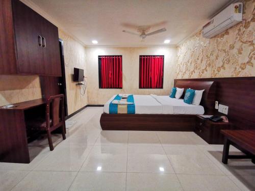 a bedroom with a bed and a desk and a television at Sai Sharan Stay Inn- Near MIDC Turbhe Navi Mumbai in Navi Mumbai