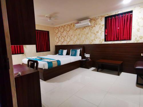 a hotel room with a bed and a desk at Sai Sharan Stay Inn- Near MIDC Turbhe Navi Mumbai in Navi Mumbai