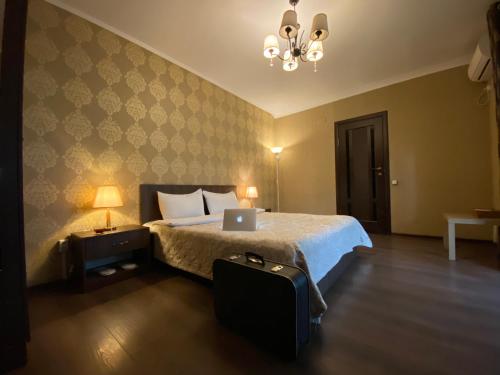 een slaapkamer met een bed met een laptop erop bij Lavitor hotel in Bisjkek