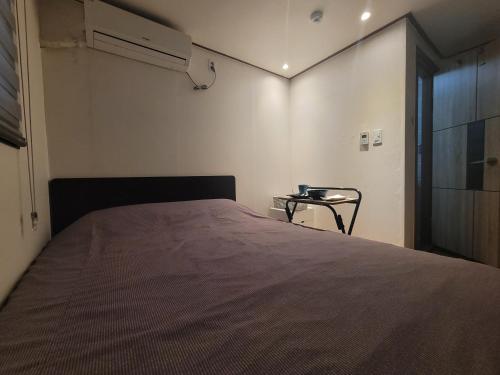 a bedroom with a large bed and a table at Olive Hostel MyeongDong in Seoul