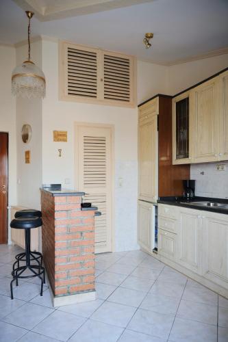 a kitchen with white cabinets and a brick counter at Apartment Blanka with a beautiful view of Trogir in Trogir