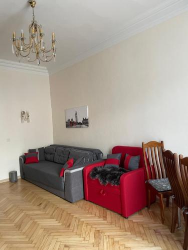 a living room with a couch and a red sofa at Freddies apartment in Kyiv