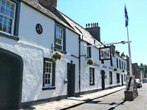 a row of white buildings on a street at Tweeddale Arms Hotel in Gifford