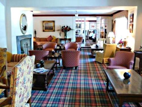 a living room filled with lots of chairs and tables at Tweeddale Arms Hotel in Gifford