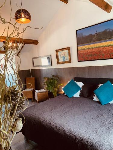 a bedroom with a large bed with blue pillows at B&B Prachtig Allemachtig in Valkenburg