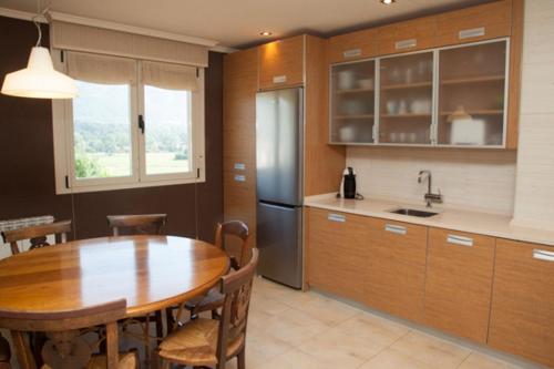 a kitchen with a wooden table and a refrigerator at Sorkun in Lacunza