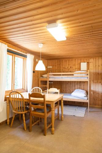 a dining room with a table and chairs and a bed at Maja Camping in Bottnaryd