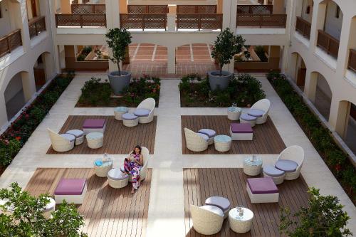 
a patio area with chairs, tables, and tables with umbrellas at Minoa Palace Resort in Plataniás
