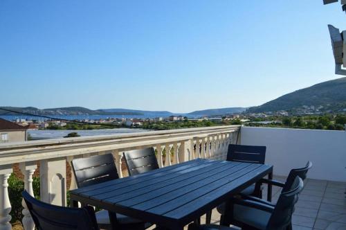 a wooden table and chairs on a balcony at Apartment Blanka with a beautiful view of Trogir in Trogir