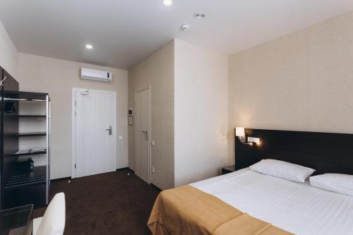 a bedroom with a large bed and a door at Optima Sumy in Sumy