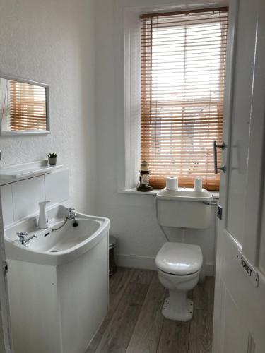 bagno bianco con servizi igienici e lavandino di The Stag Head Hotel a Edimburgo