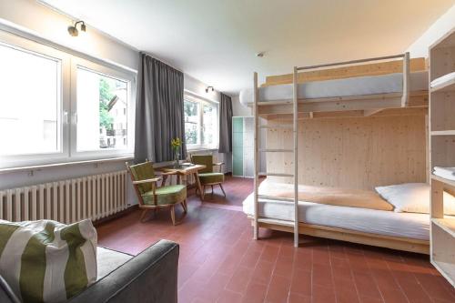 a bedroom with two bunk beds and a table and chairs at FinKa in Malles Venosta