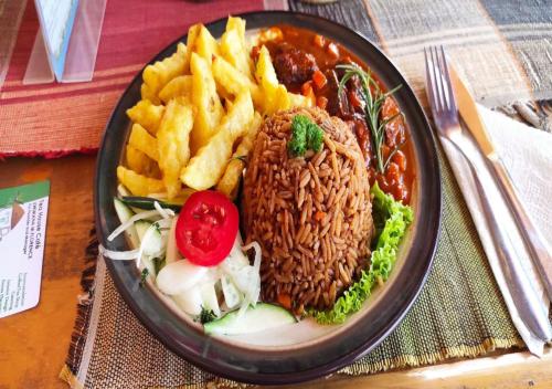 a plate of food with rice and french fries at Tea House BNB in Kigali