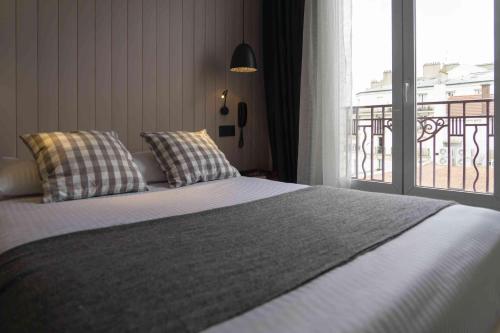 a bedroom with a bed and a large window at Hotel SUB in Asnières-sur-Seine