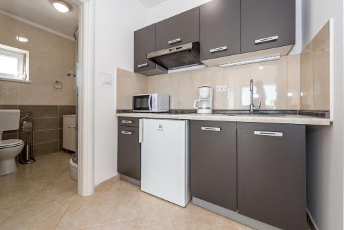a small kitchen with a sink and a microwave at Villa Mirta in Tisno